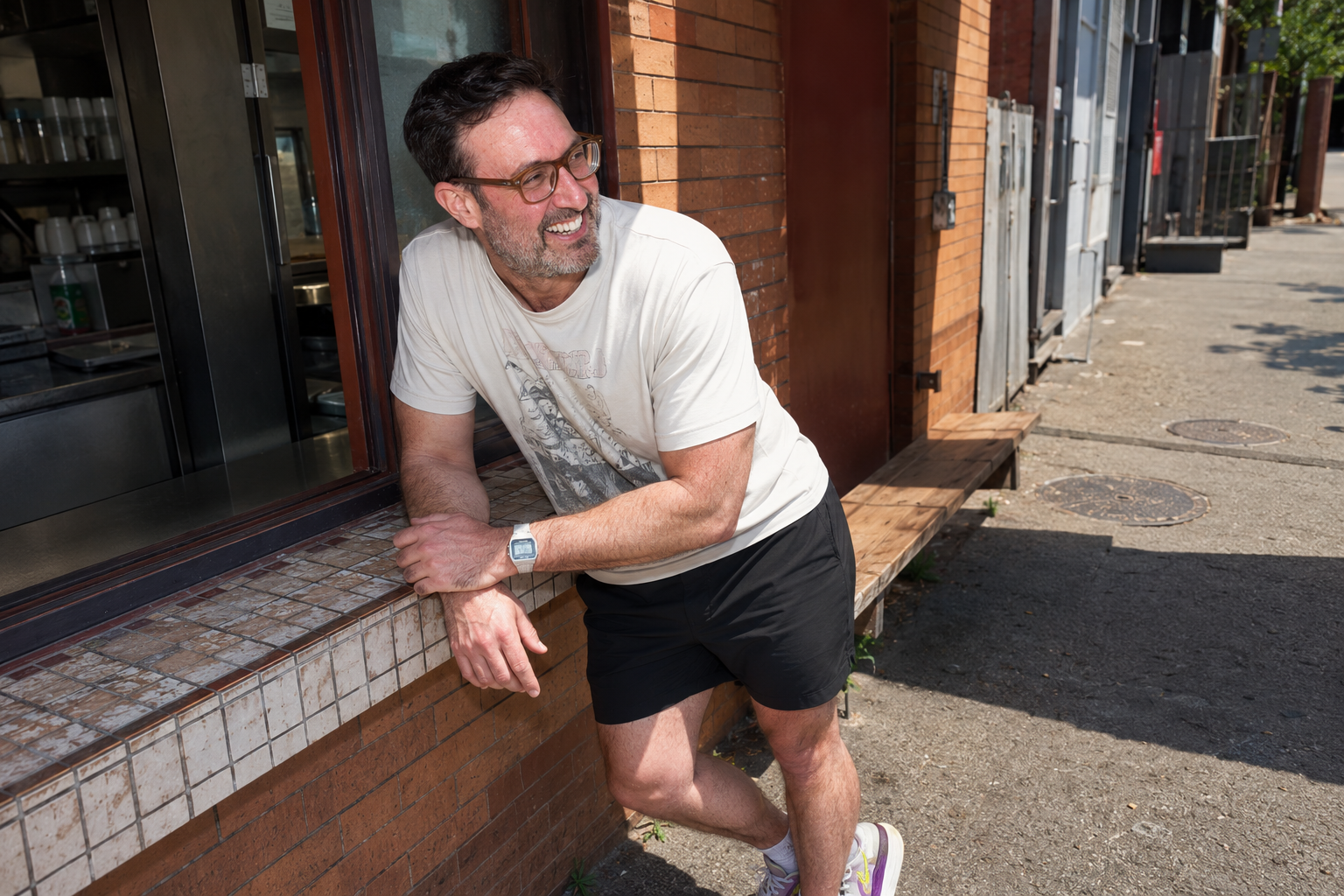 Ben Corber walking past a city storefront window
