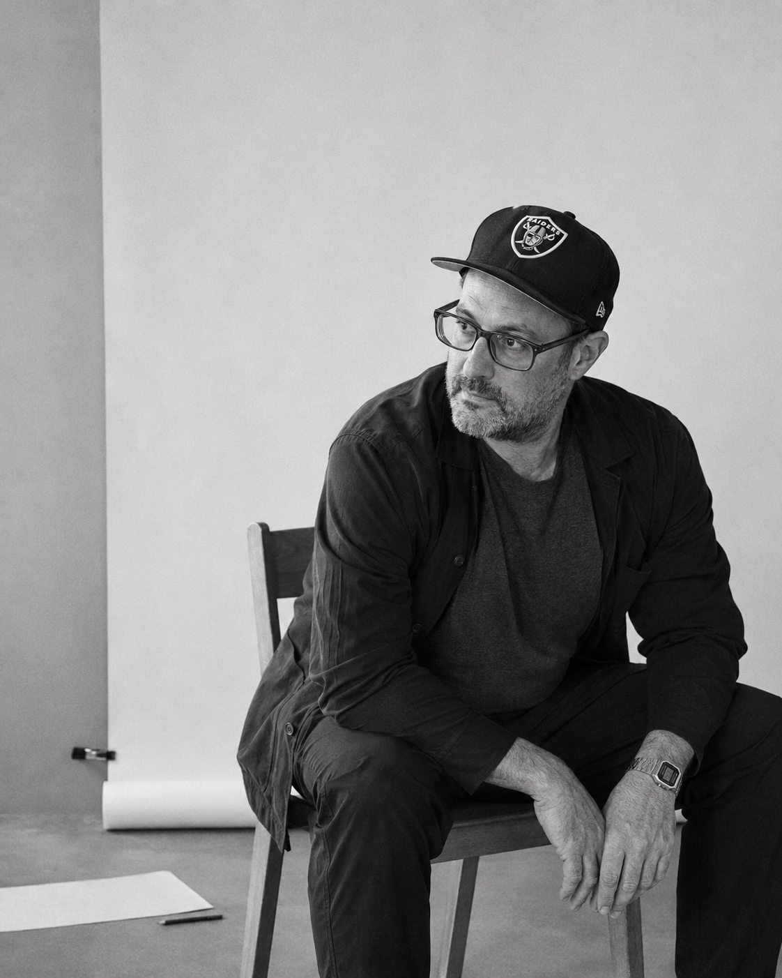 Ben Corber seated in a black-and-white studio portrait